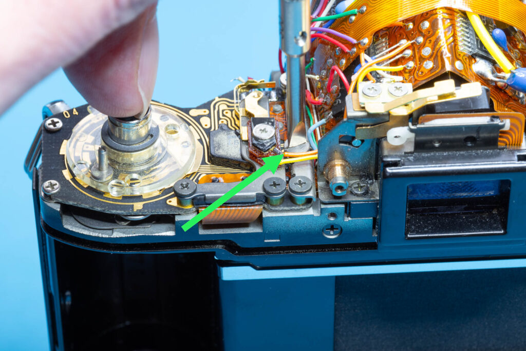 Canon A-1: Removal of mirror box - Loosen the slotted screw of the SAVE connector plate