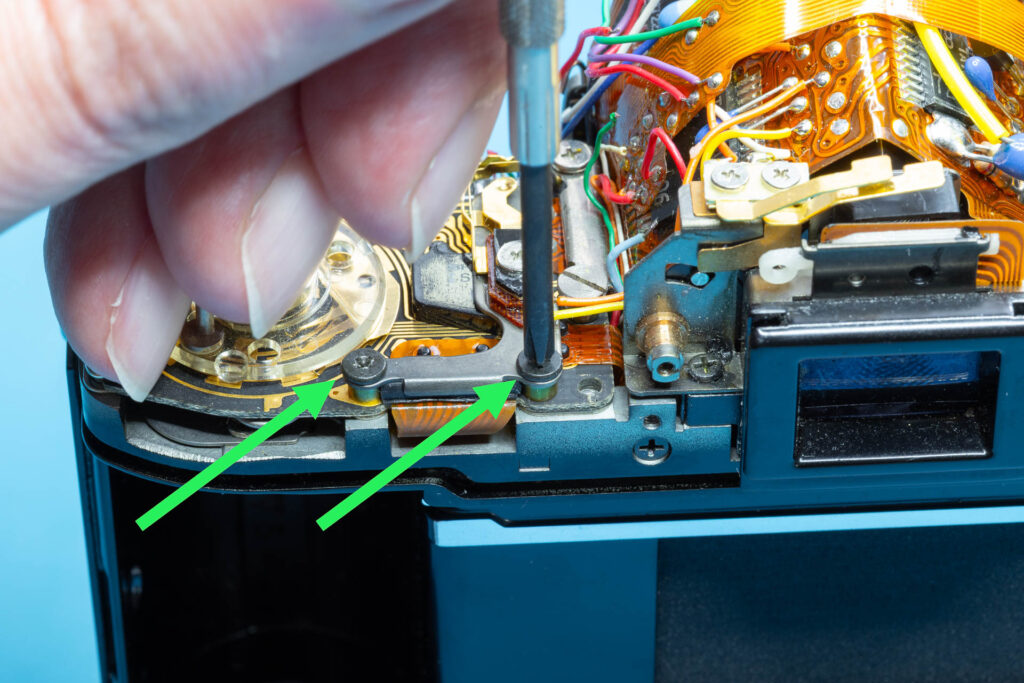 Canon A-1: Removal of mirror box - Remove both screws of the DD connector plate
