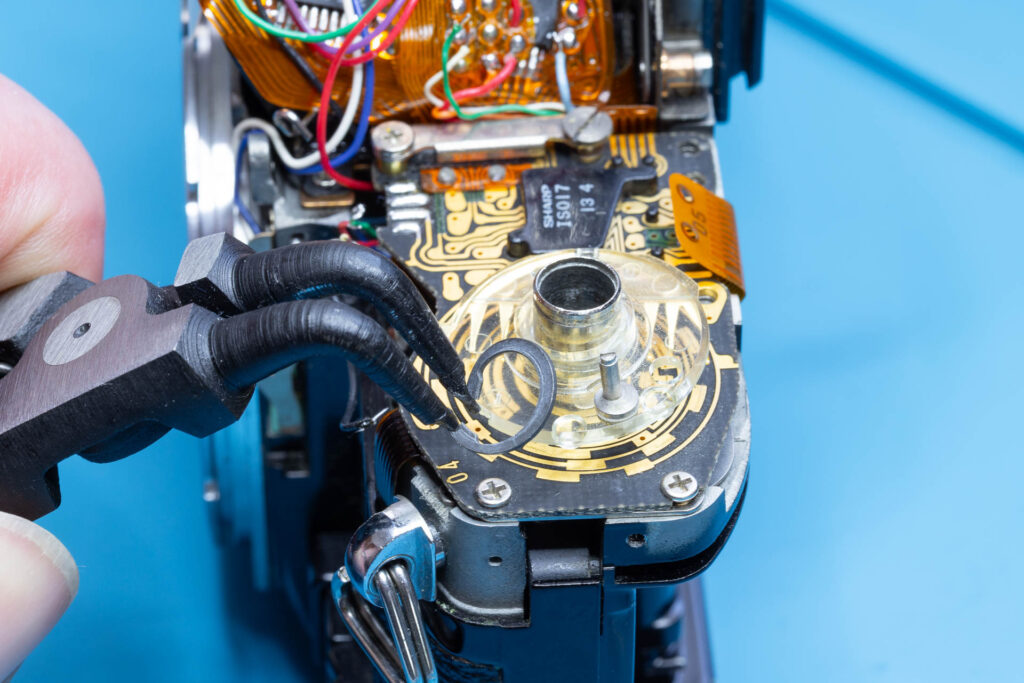 Canon A-1: Removal of mirror box - Remove the snap ring securing the ASA film speed brush plate