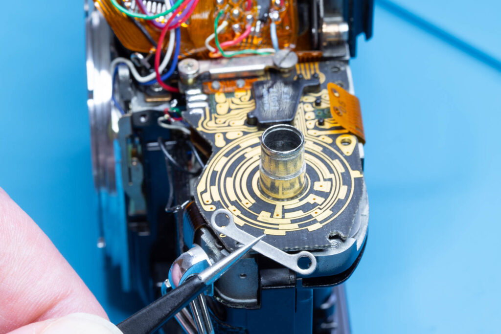 Canon A-1: Removal of mirror box - Pull out the metal bar from under the SV circuit board