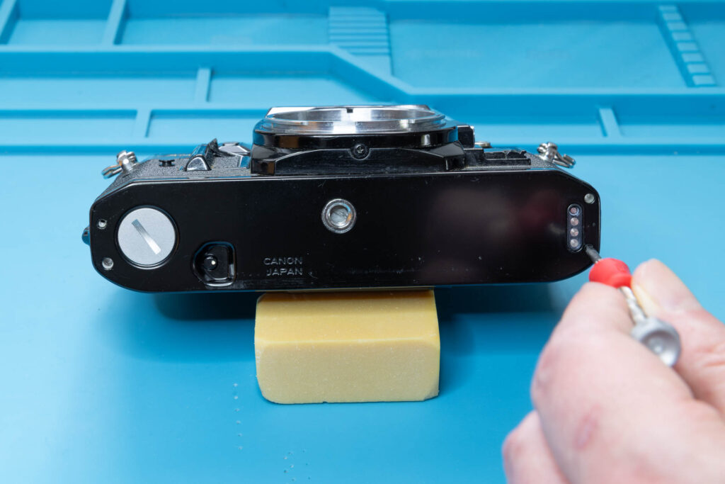 Canon A-1: Remove screw #2 that holds the bottom cover