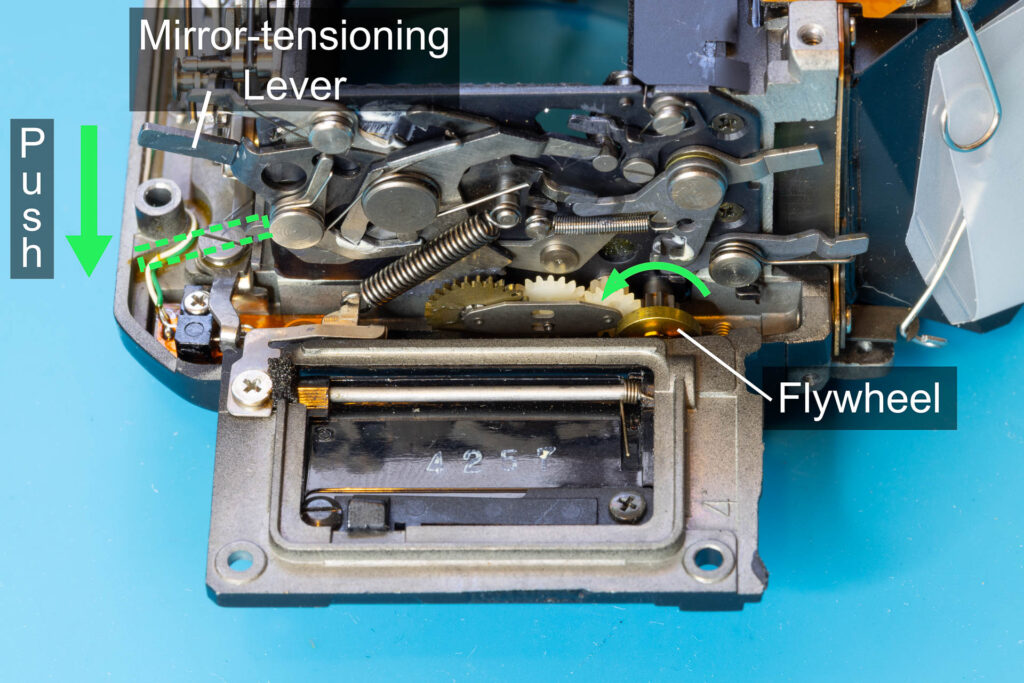 Canon A-1: Push down the mirror-tensioning lever to lift up the mirror
