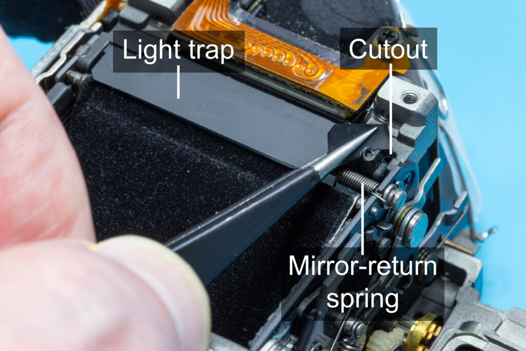 Canon A-1: Peel back the light trap to see mirror-return spring and cutout