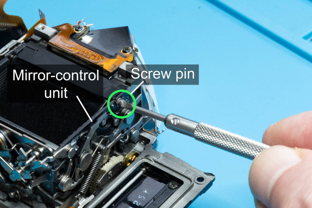 Canon A-1: Remove screw pin of mirror-return spring from mirror-control unit