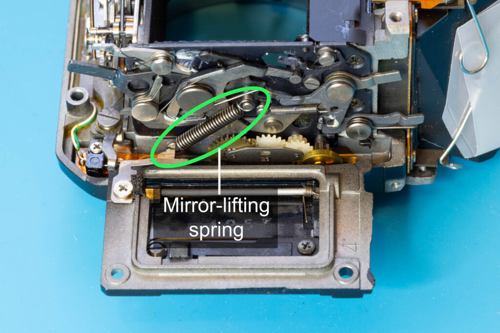Canon A-1: Mirror-lifting spring, attached to the mirror-control unit of the mirror box