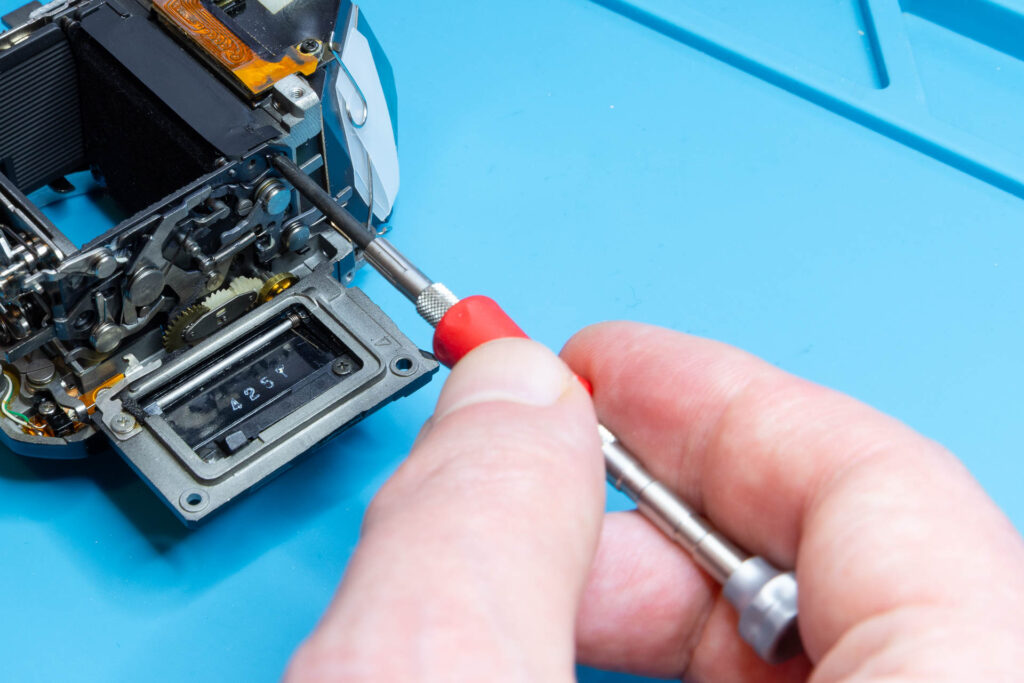 Canon A-1: Remove three screws to remove the mirror-control unit