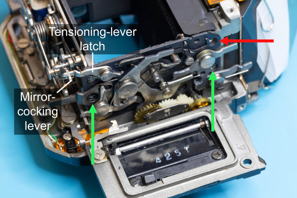 Canon A-1: Screw the mirror-control unit onto the right side of the mirror box (Don't screw in upper right screw!)