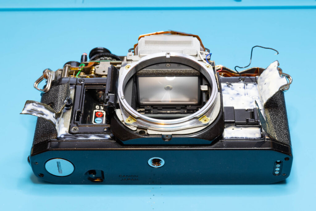 Canon A-1: Glue applied to both the leatherette and the camera chassis