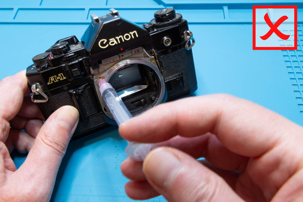 Canon A-1: Applying oil through a screw hole on the front of the camera. Don't!